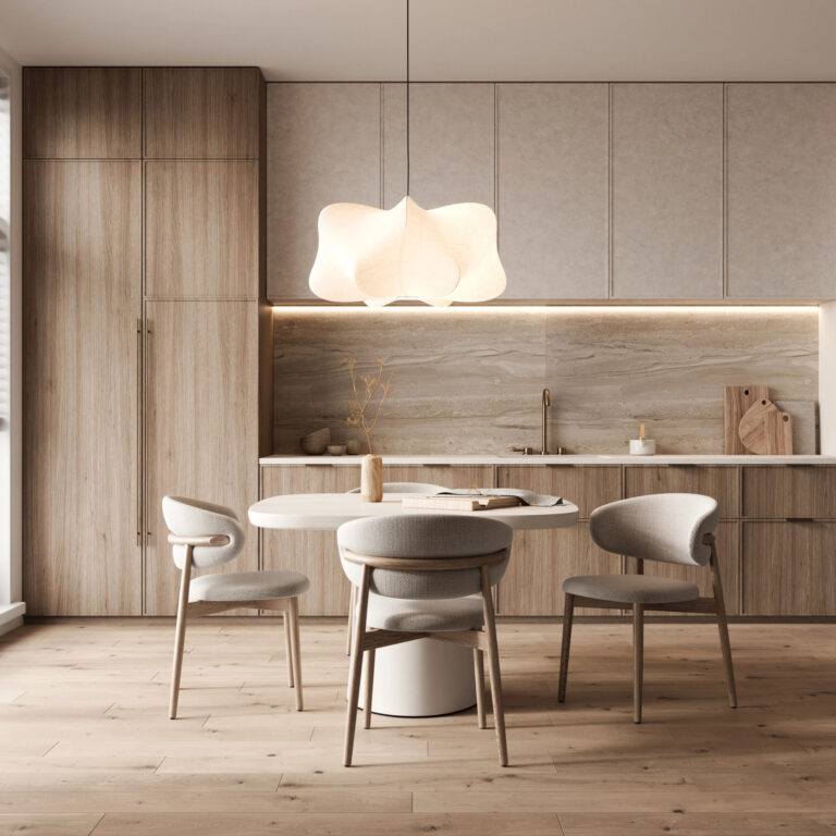 Cocina y comedor minimalistas con gabinetes de madera clara, mesa redonda blanca, cuatro sillas tapizadas, lámpara colgante escultural y decoración neutra.